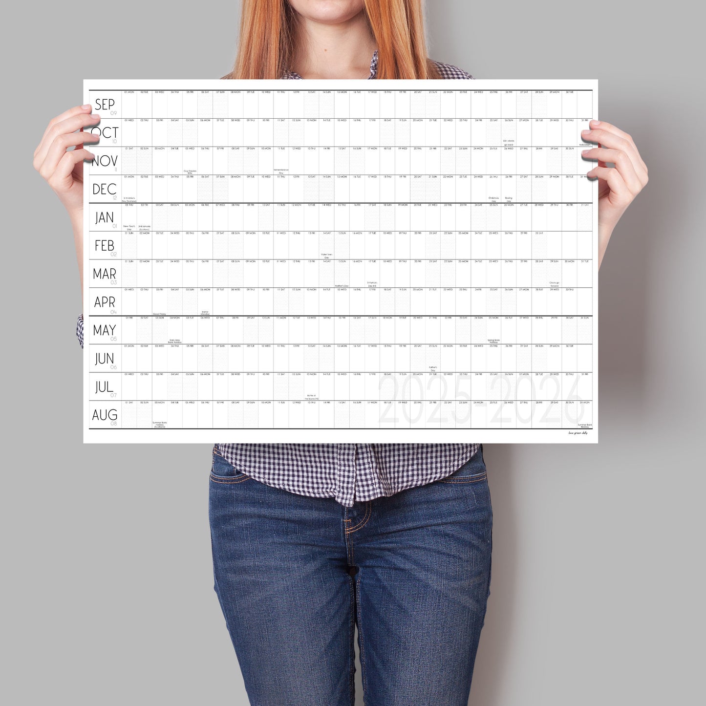 Lady holding up black and white wall planner for the academic year 2025 to 2026