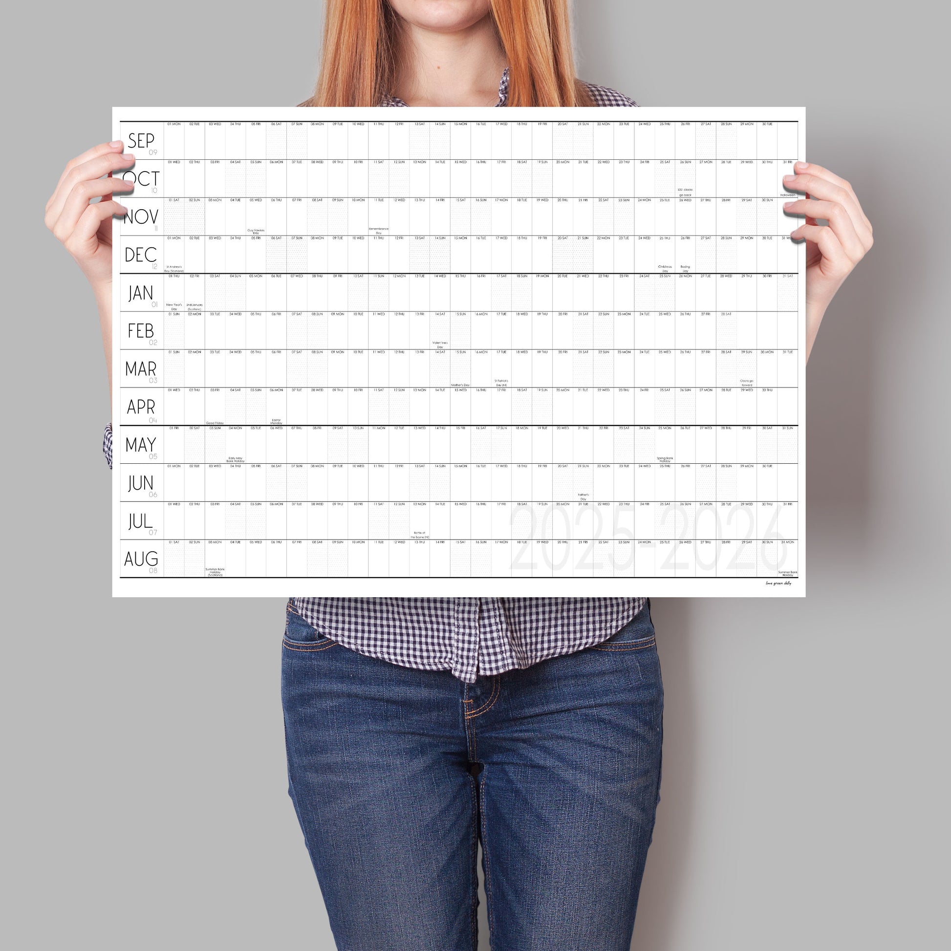 Lady holding up black and white wall planner for the academic year 2025 to 2026