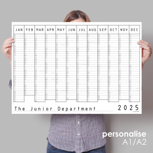 Lady holding up black and white wall planner for 2025