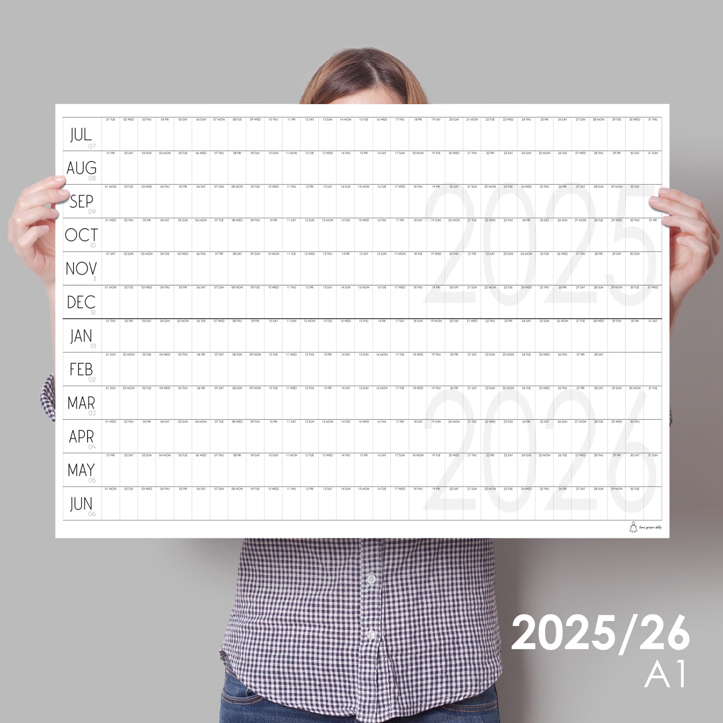 lady holding up large wall calendar for 2025/2026