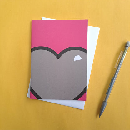 pink greeting card with love heart against yellow background