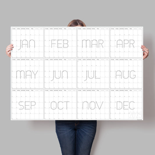 Lady holding up black and white wall planner for 2025