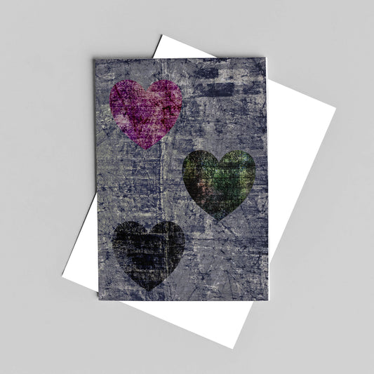 Grey greeting card featuring three love hearts over white envelope 